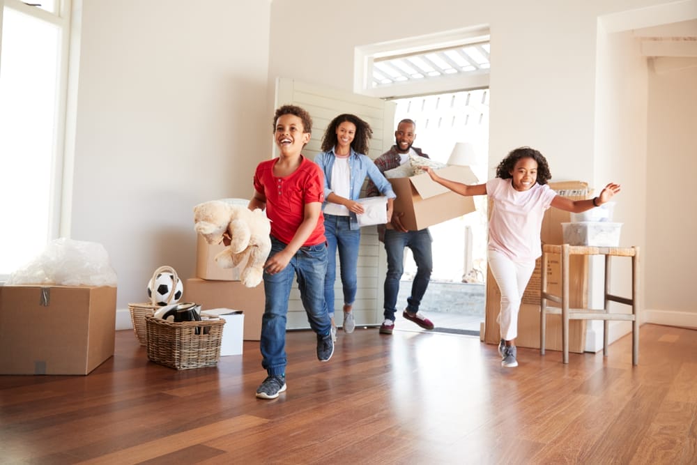 Excited,Family,Carrying,Boxes,Into,New,Home,On,Moving,Day